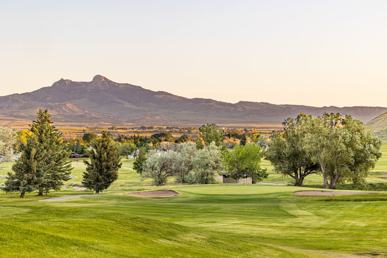 View of the golf course with the mountains in the background and beautiful greens