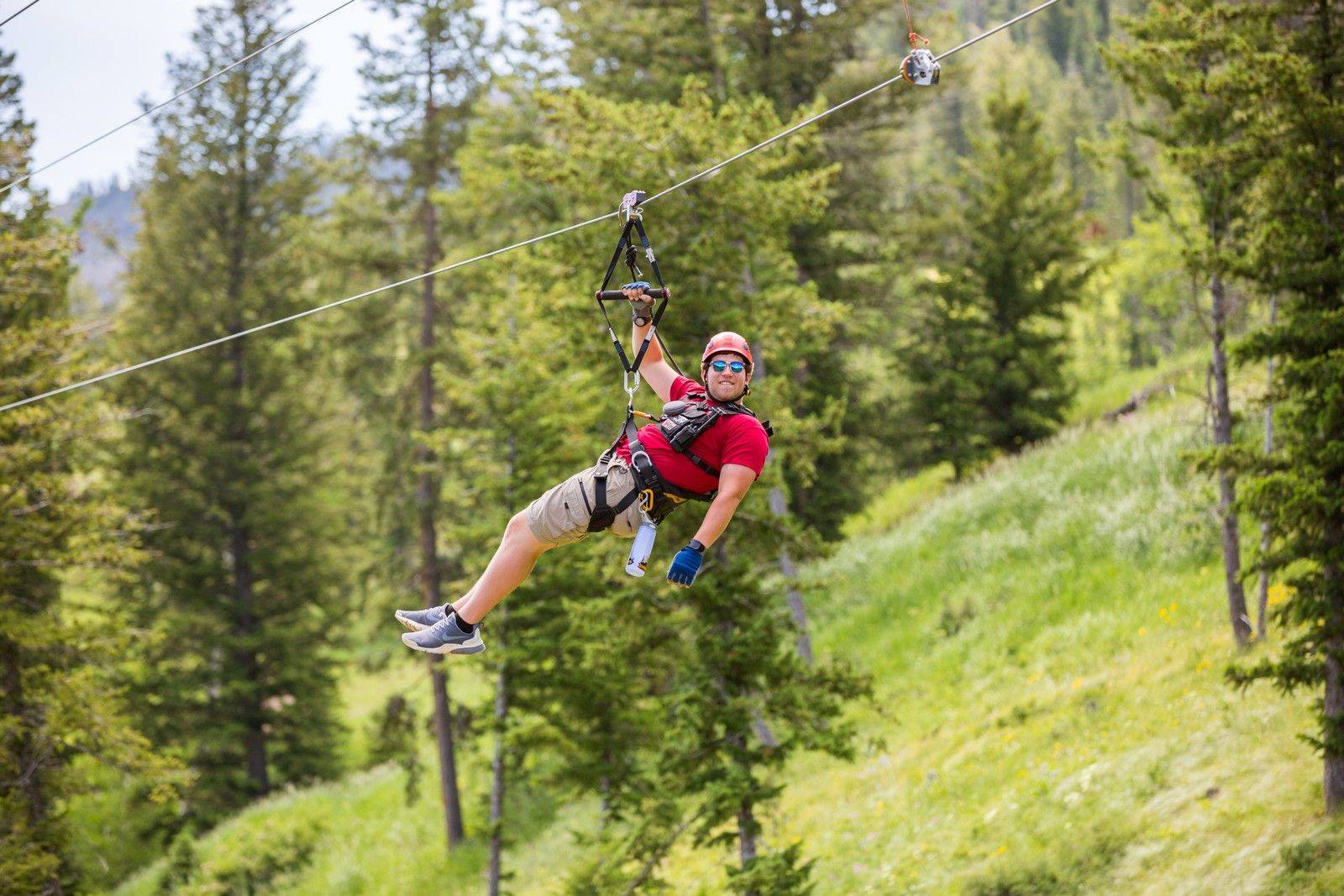 A man hanging from a zipline