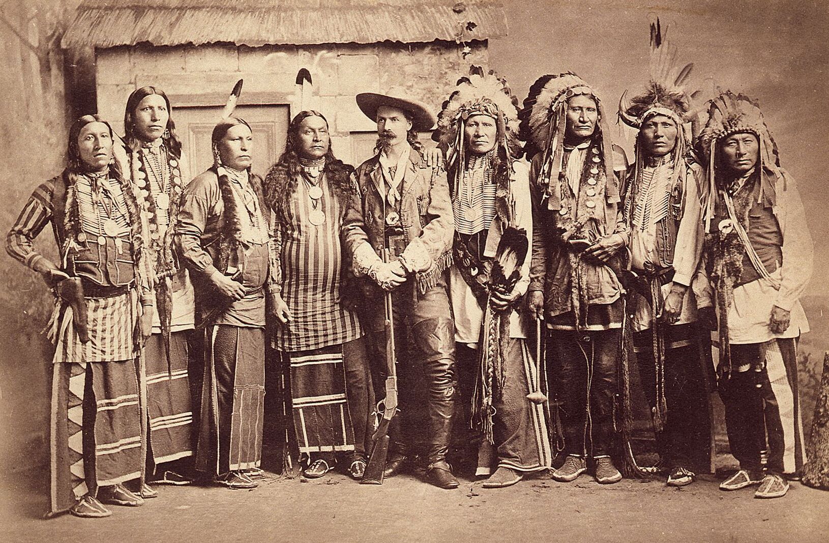 A group of indigenous men posing with Buffalo Bill