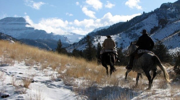 Two people on horses in the mountains