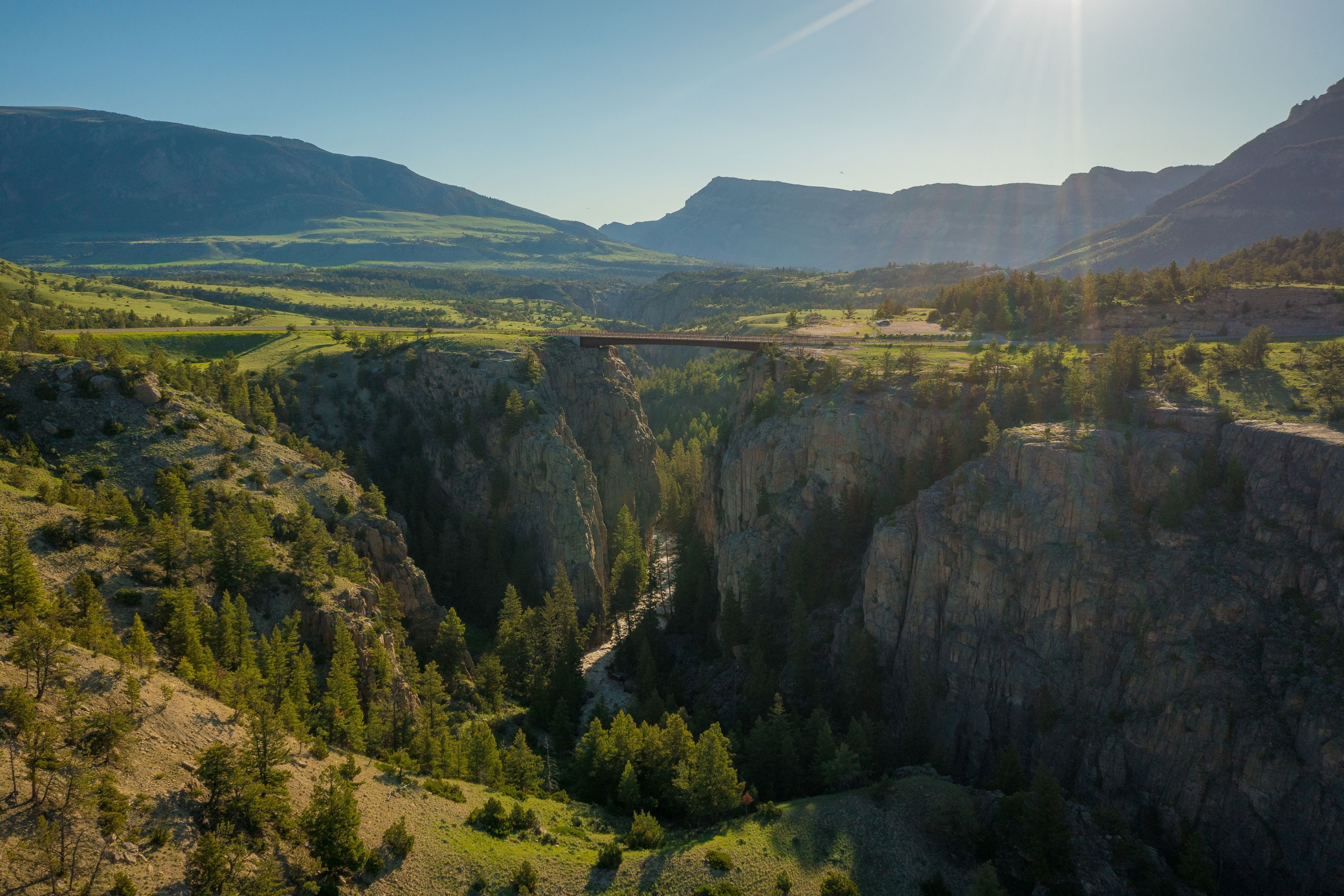 A large canon in the mountains with a bridge going across it.