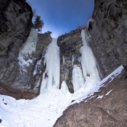 A person ice climbing on the side of a mountain