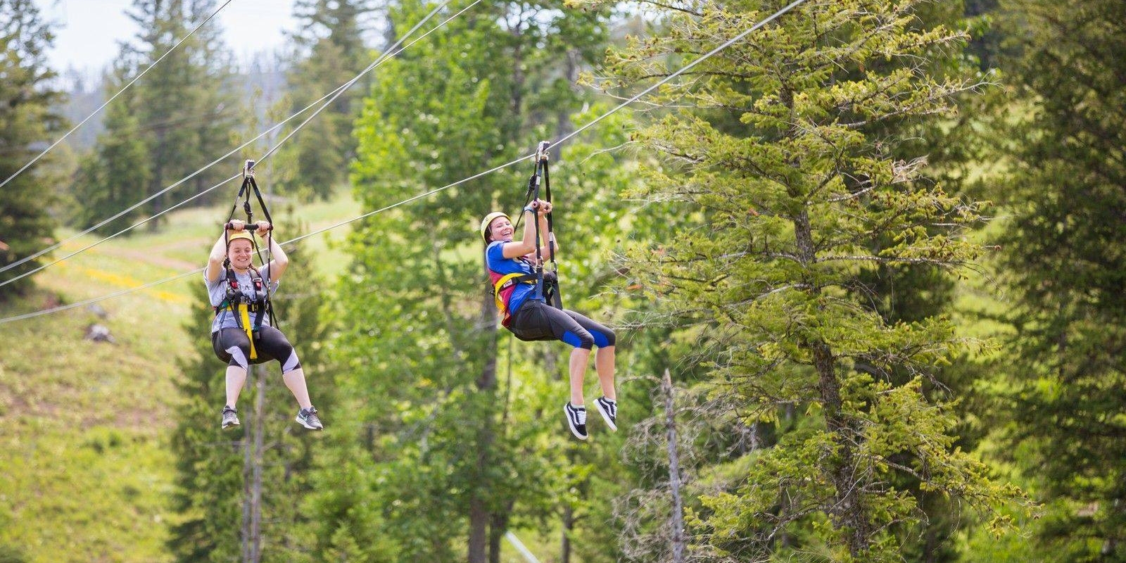 Two women zip lining