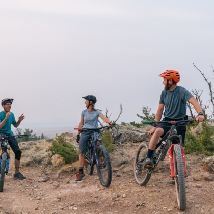 Three people biking on a cliff