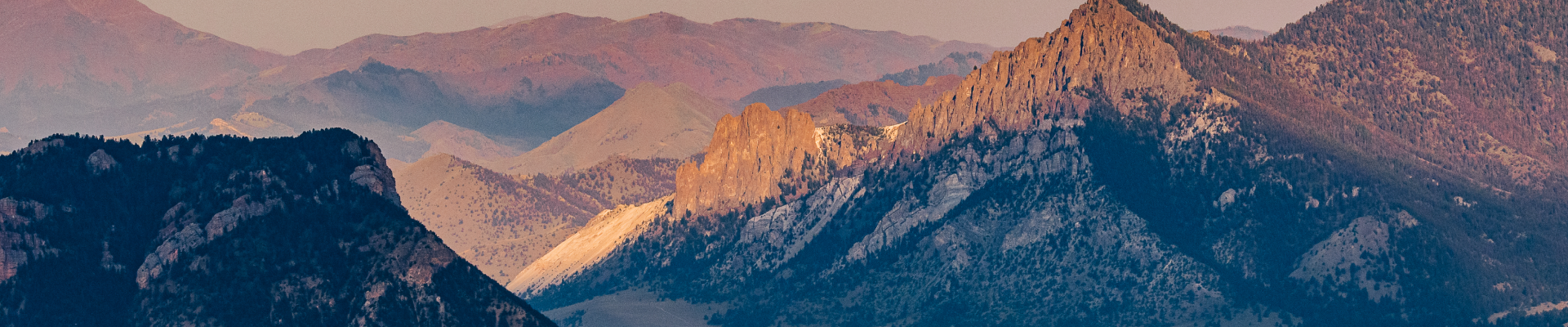 An aerial view of the mountain peeks with snow and the sun shinning on them