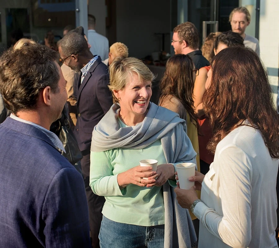 Two women and a man talking at a conference