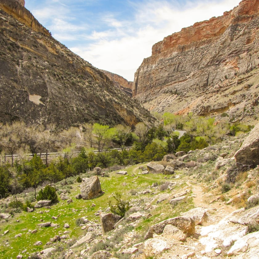 A beautiful canyon path featuring rocky terrain and lush grass along the sides