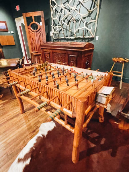 A fun foosball table is set up in a room featuring a chic cowhide rug on the floor