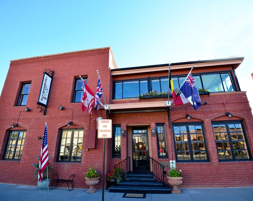 A brick building's facade with colorful flags waving in the breeze, showcasing a vibrant and welcoming atmosphere.