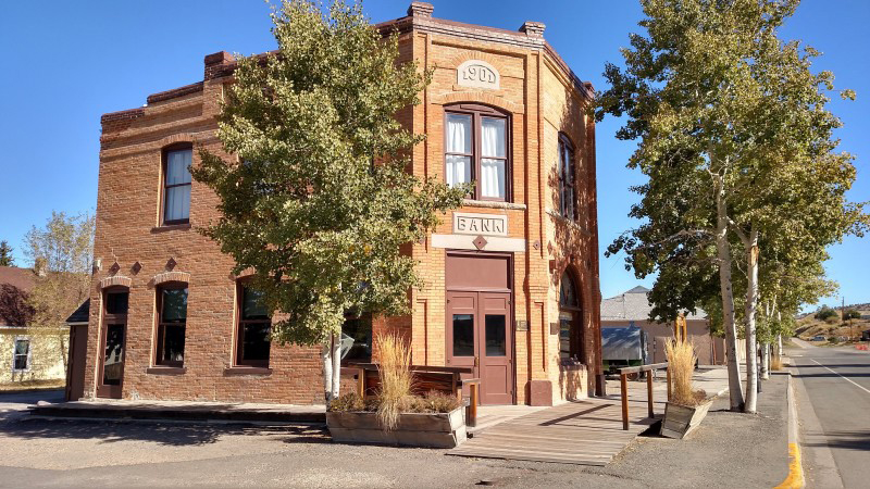 A large brick building featuring a prominent wooden door at the entrance.