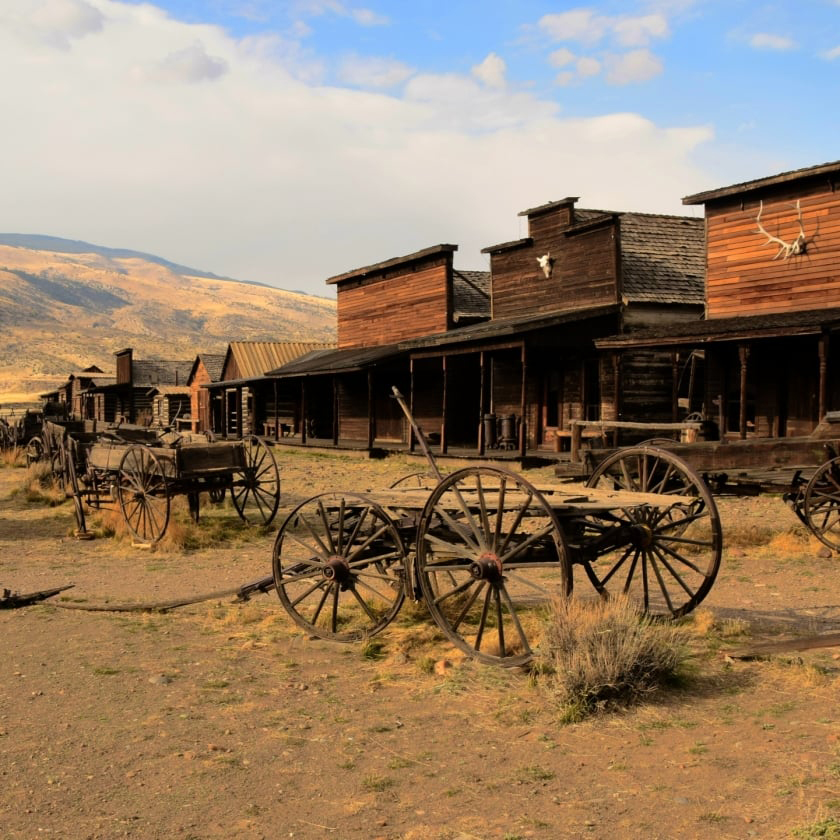 A classic western town with aged wooden buildings and horses, showcasing the spirit of the Wild West.