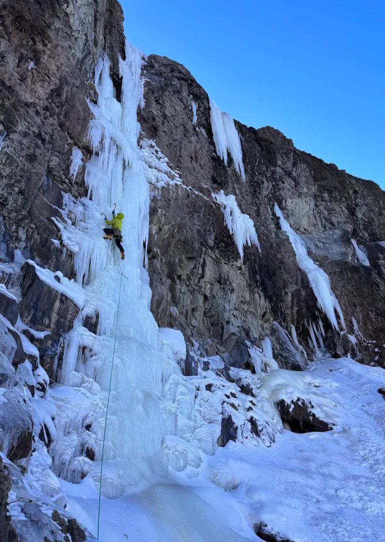 A person climbing a mountain in the winter