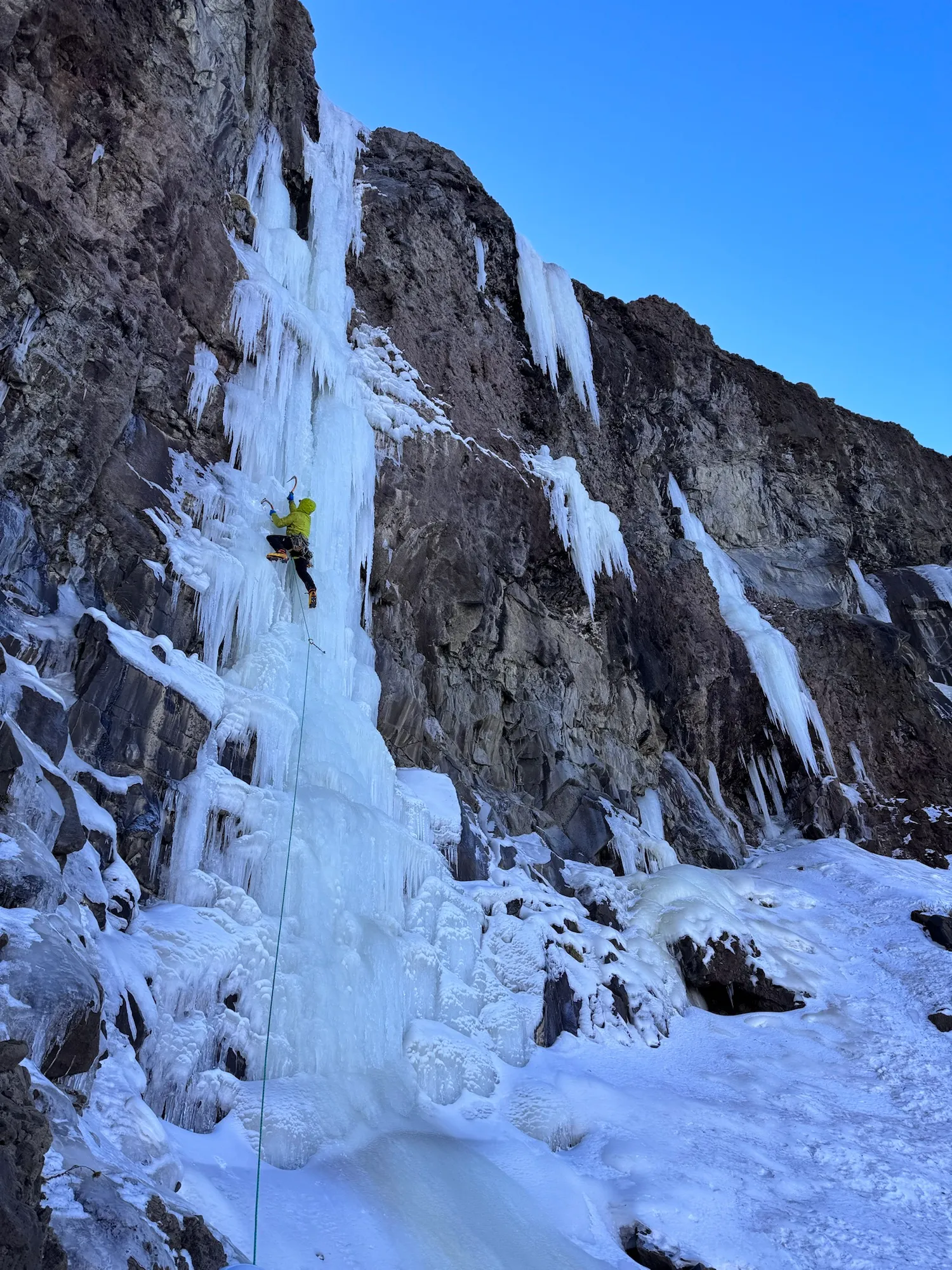 A person climbing a mountain in the winter