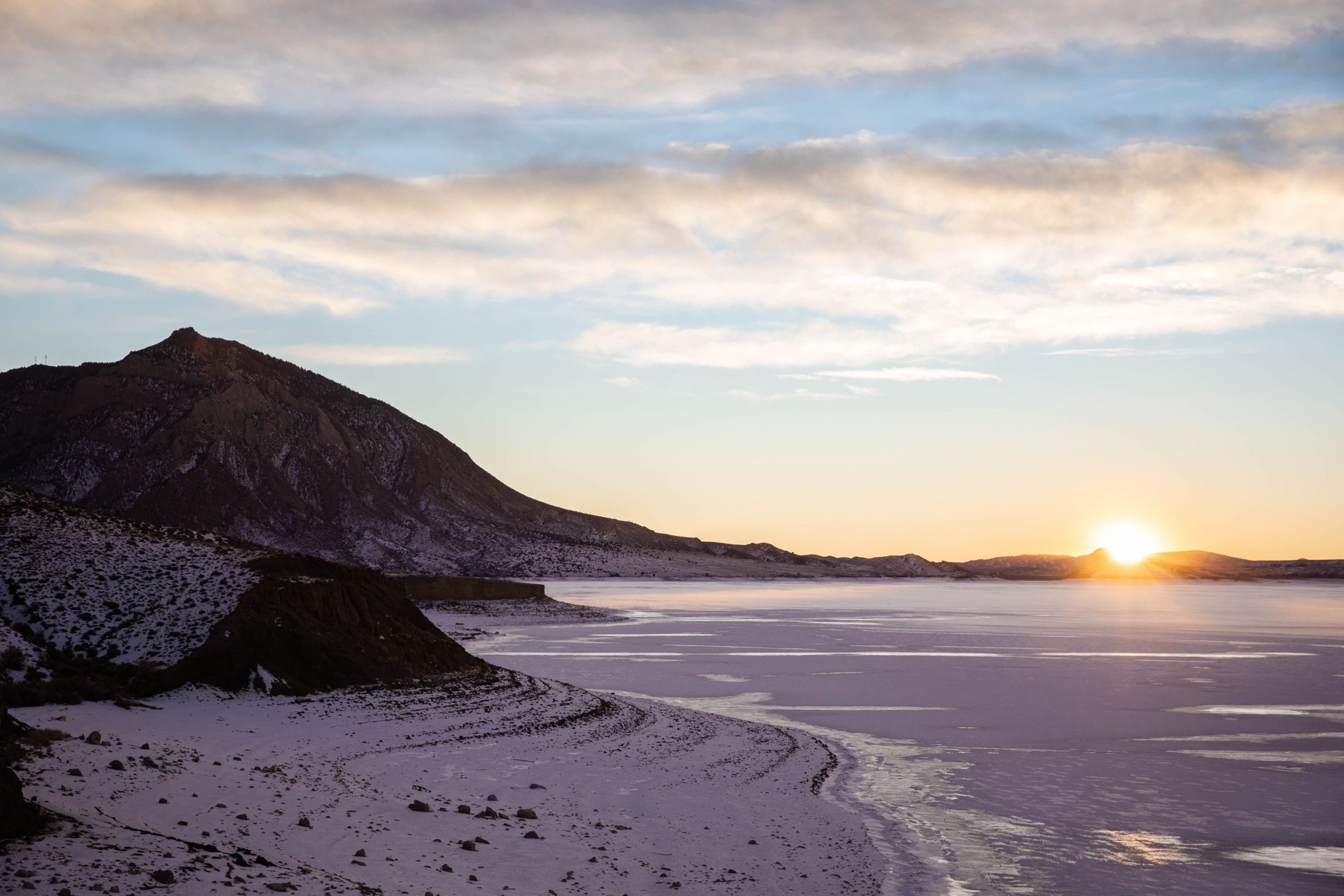 The shore line of a lake at sunset