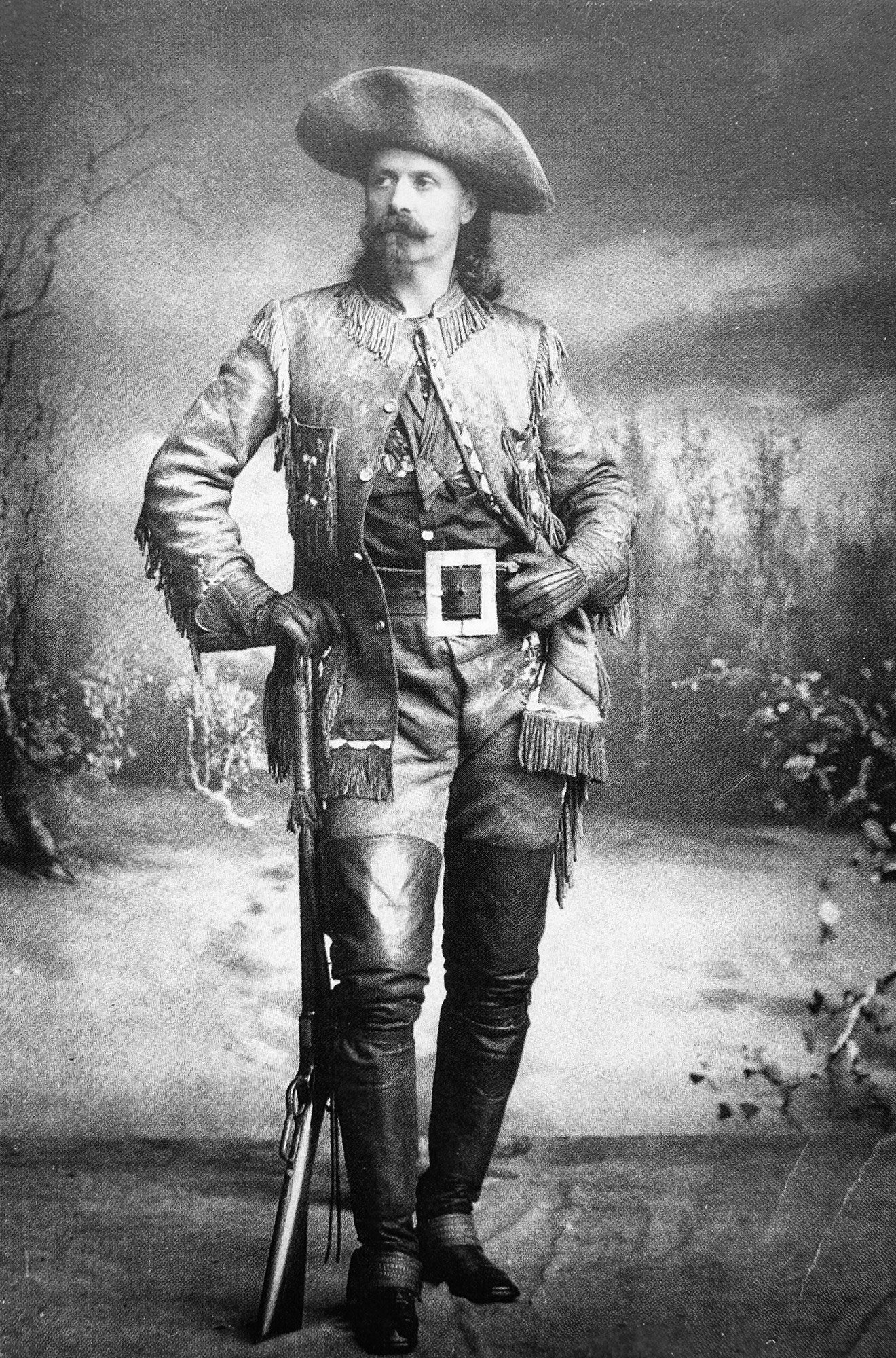 Buffalo Bill: A black and white photo of a man dressed in a classic cowboy outfit, complete with a hat and boots