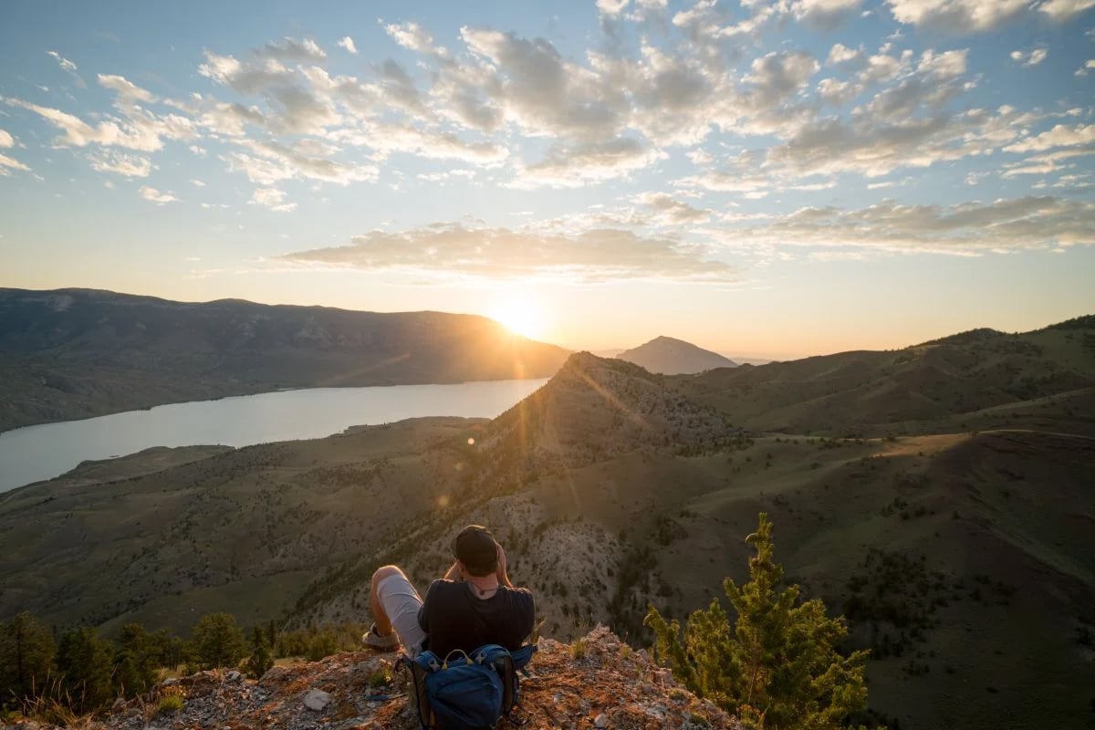 A men taking a picture at the top of buffalo bill state park during the sunset