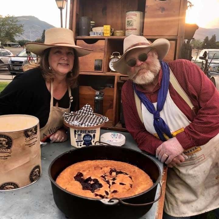 Two people selling a pie at a chuckwagon