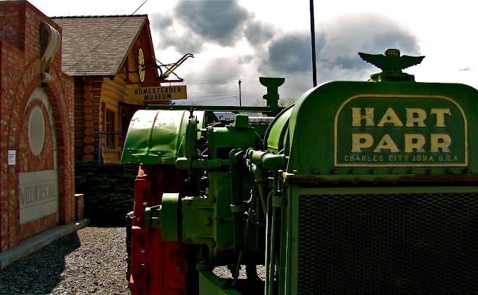 Exyerior of Homesteader Museum with a green tractor parked