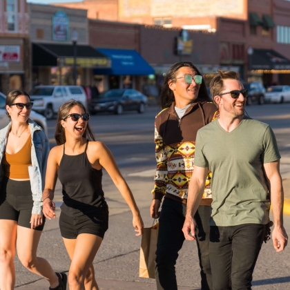 A group of people walking down the sidewalk while shopping in Yellowstone.