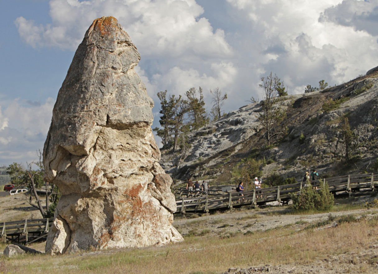 A large rock formation stands out, characterized by its rough surface and striking geological features