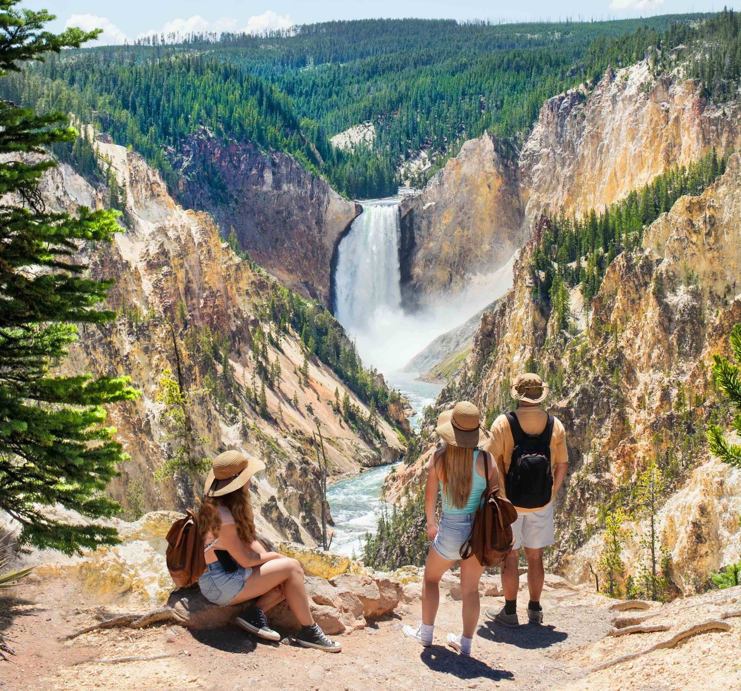 3 People looking off a cliff at a waterfall