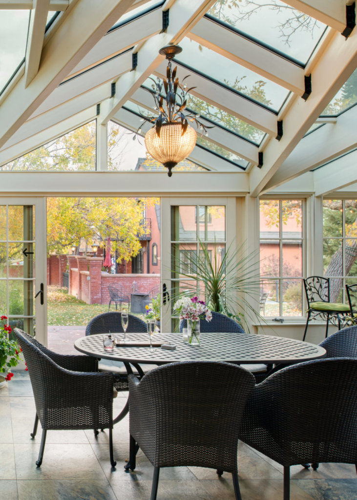 An outdoor eating area inside an room full of windows