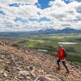Woman with red jackate hiking in the Yellowstone alone